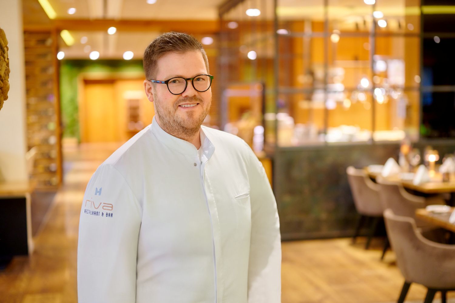 Mike Deuschel, Küchenchef im Restaurant RIVA des Wein- und Seminarhotels Kaisergarten Deidesheim/ Pfalz. Hier, mit Blick auf die offene Showküche im Hintergrund.